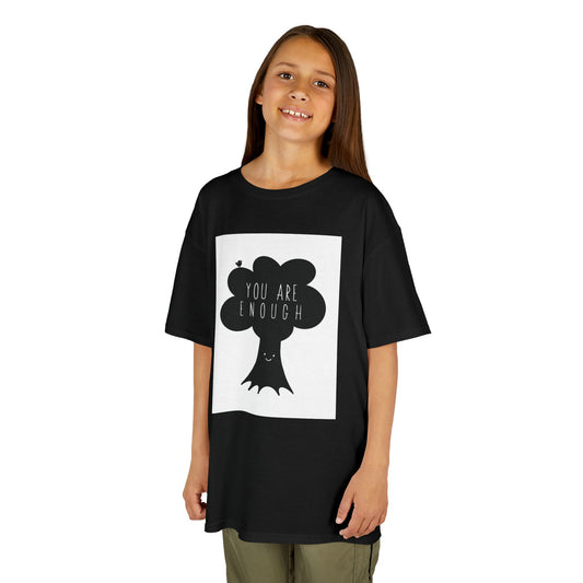 Child wearing a black t-shirt with a graphic design of a kawaii tree with a bird and the text "You Are Enough" on a white background
